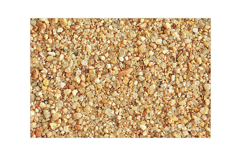 Das Bild zeigt eine Nahaufnahme von feinem, beigefarbenem Sand. Die einzelnen Sandkörner sind deutlich erkennbar und haben eine ungleichmäßige Form. Die Farben reichen von hellem Beige bis hin zu leicht bräunlichen Tönen. Der Sand wirkt natürlich und unberührt.