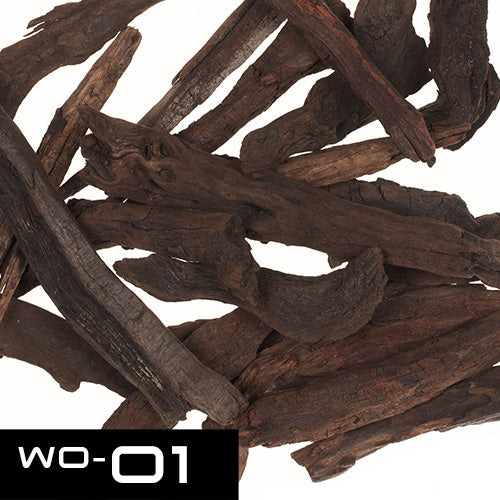 Beschreibung des Bildes
Das Bild zeigt eine Ansammlung von Holzstücken. Diese Holzstücke sind von dunkler Farbe, teilweise fast schwarz, und haben eine unregelmäßige, natürliche Form. Sie wirken trocken und leicht rissig. Die Holzstücke sind unterschiedlich lang und dick. Die Oberfläche ist rau und weist Spuren von Verwitterung auf. Im unteren rechten Bildbereich ist eine weiße Beschriftung angebracht: "WO-01".