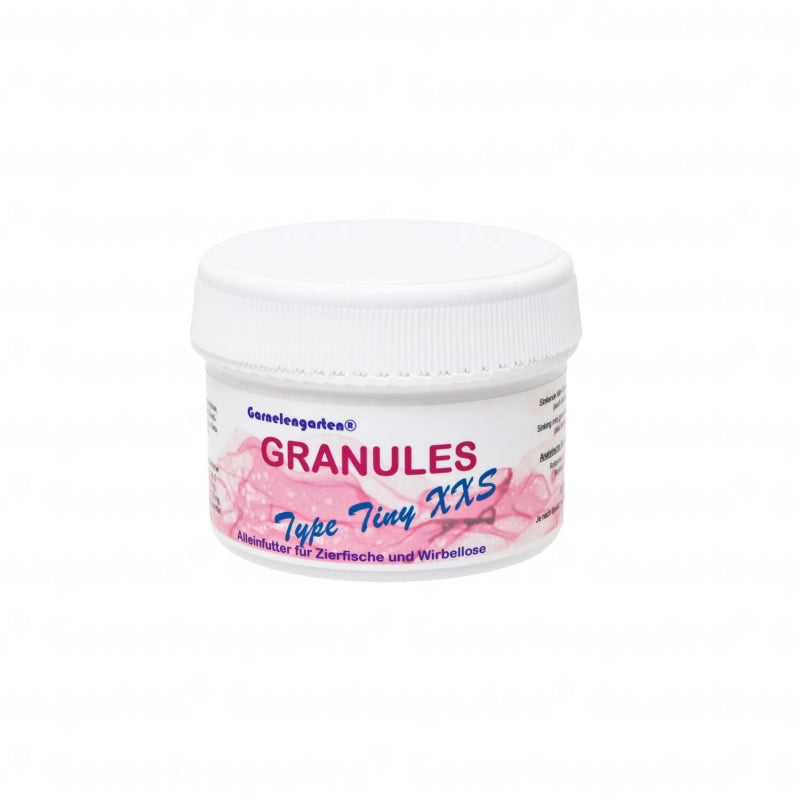 Weiße Plastikdose , gefüllt mit winzigen Futterpellets. Beschriftung: Garnelengarten® Granules Type Tiny XXS. Alleinfutter für Zierfische und Wirbellose.